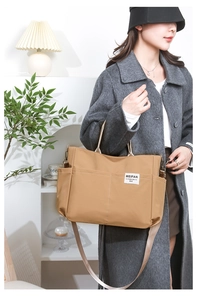 Side view of woman wearing khaki nylon tote bag with adjustable shoulder strap