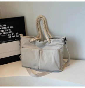 Detail view of corduroy tote bag featuring thick cotton rope handles and two front pockets