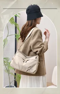 Beige nylon crossbody bag styled with a tweed blazer for a chic lifestyle look