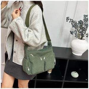 Détail du sac cabas en velours côtelé vert olive montrant les poches sur un modèle