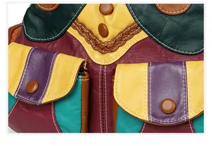 Detail of multi-color leather handbag featuring braided accents and contrast stitching