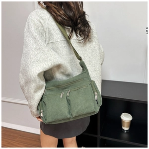 Détail du sac fourre-tout en velours côtelé vert foncé avec poches zippées et bandoulière