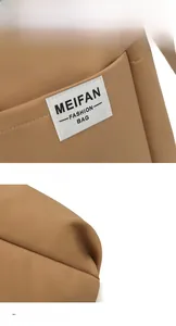 Close-up of the woven logo label and pleat detail on a brown nylon shoulder bag