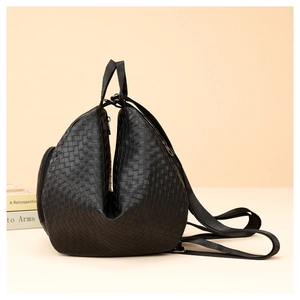Detail of black woven texture on fashionable faux leather backpack with metallic zipper