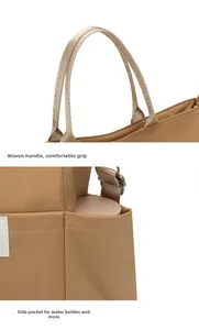 Detail of khaki nylon tote bag featuring woven handles and a functional side water bottle pocket