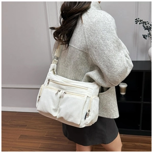 Détail du sac fourre-tout en velours côtelé blanc avec poches zippées et bandoulière
