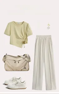 Flat lay of khaki nylon crossbody bag styled with mint tee and white wide-leg trousers