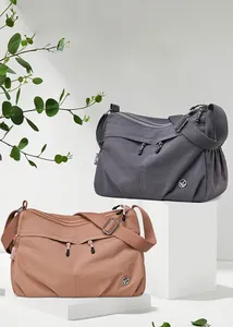 Detailed view of water-resistant nylon shoulder bags with multiple zipper compartments