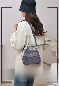 Détail d'un sac bandoulière en nylon gris foncé avec plusieurs compartiments zippés
