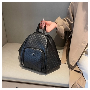 Detailed view of black woven texture leather and metallic kangaroo logo on backpack