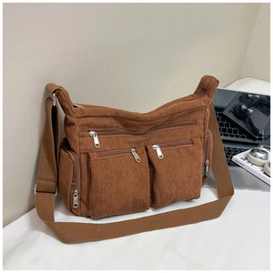 Détail du sac bandoulière en velours côtelé marron avec plusieurs poches et sangle
