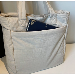 Close-up of the front pocket on a nylon tote bag showing iPad storage capacity