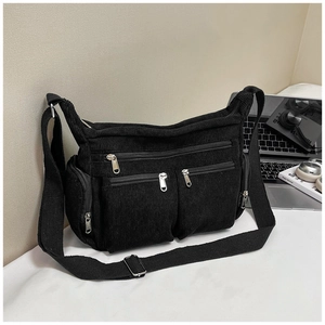 Détail du sac fourre-tout en velours côtelé noir montrant des poches et des fermetures
