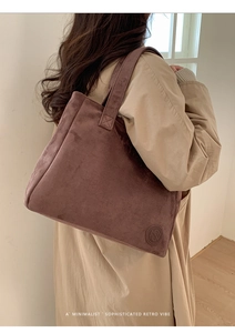 Detail view of large retro suede tote bag showing texture and embossed leather logo patch