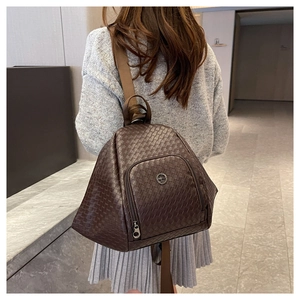 Detailed close-up of dark brown woven texture and metal kangaroo logo on a backpack