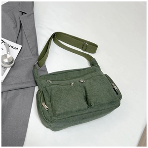 Gros plan du sac en velours côtelé vert olive avec poches frontales et fermetures argentées