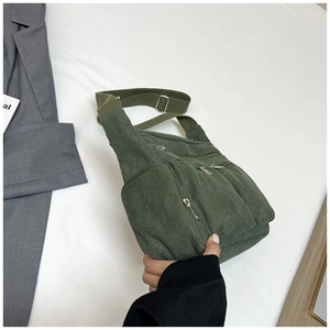 Détail du sac en velours côtelé vert avec plusieurs poches et bandoulière réglable