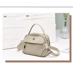 Détail du sac à main en nylon kaki avec trois compartiments et bandoulière réglable
