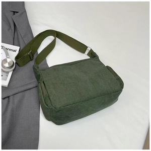 Détail du sac bandoulière en velours côtelé vert foncé avec poche zippée latérale