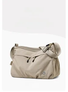 Close-up of khaki waterproof nylon shoulder bag with zipper compartments and logo