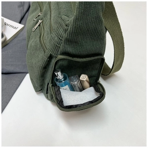 Détail de la poche latérale zippée et texture en velours côtelé du sac cabas vert