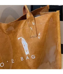 Close-up of brown Tyvek tote bag featuring a crinkled texture and clear glossy overlay