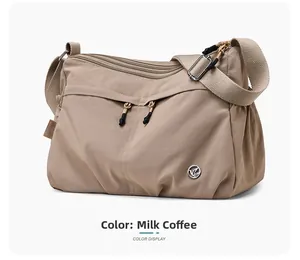 Detail view of khaki water-repellent nylon crossbody bag with multi-zipper pockets