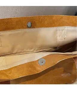 Detail of orange DuPont paper tote bag with magnetic clasp and beige inner lining
