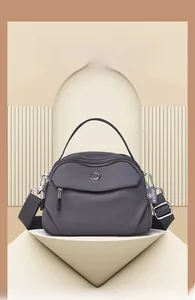 Détail du sac bandoulière en nylon gris foncé avec fermetures éclair et sangle large