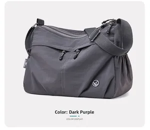 Detail of dark purple water-resistant nylon bag with side logo and adjustable strap