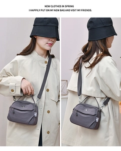 Détail du sac bandoulière en nylon gris avec double zip et bandoulière réglable pour femme
