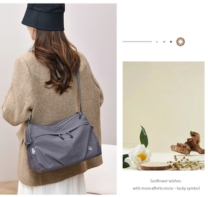 Detailed view of grey nylon shoulder bag with multi-zipper layers and model back shot