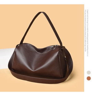 Detail of soft dark brown lychee grain leather handbag with stylish metal ring zipper pull