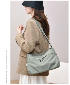 Detail of light green waterproof nylon shoulder bag with multi-zipper pockets