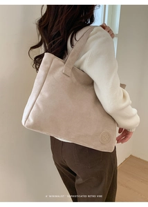Detailed view of a minimalist large faux suede tote bag with embossed circular logo