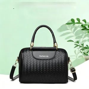 Close-up of black woven Boston handbag with luxury gold hardware and logo detail