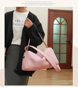 Close-up of pink litchi grain texture on crossbody bag with stylish wide strap and logo