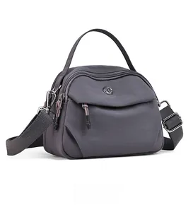 Détail du sac bandoulière en nylon gris foncé avec fermetures éclair et sangle réglable