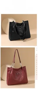 Detail of woven texture and metal chain strap on large black and burgundy tote bags