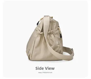 Side view of beige water-resistant nylon shoulder bag showing elastic pocket and zipper