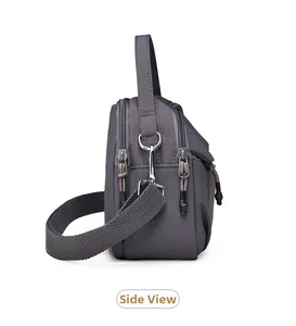 Détail du sac bandoulière en nylon gris avec double zip et sangle tissée épaisse