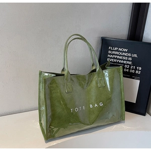 Close-up of a glossy lime green translucent tote bag with white TOTE BAG text print