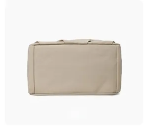 Detailed bottom view of the waterproof beige nylon tote bag with reinforced stitching