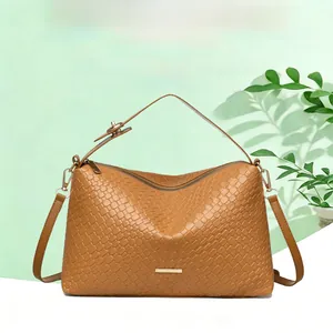 Close-up of brown woven texture handbag with metal zipper and elegant brand detail