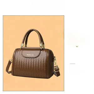 Close-up of brown woven bucket bag with champagne gold hardware and adjustable strap