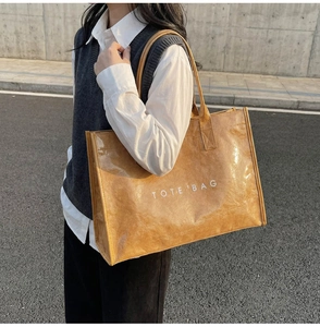 Outdoor model shot of a camel Tyvek tote bag with white TOTE'BAG print detail