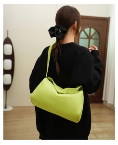 Detailed lime green lychee leather shoulder bag worn on back in indoor home setting
