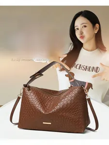 Macro detail of brown woven texture and gold hardware on minimalist shoulder bag