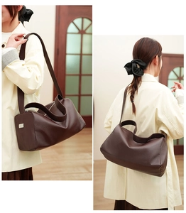 Detail view of dark brown pebbled leather texture on minimalist crossbody pillow bag
