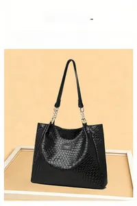 Detailed view of black woven tote bag featuring silver chain and branded leather label